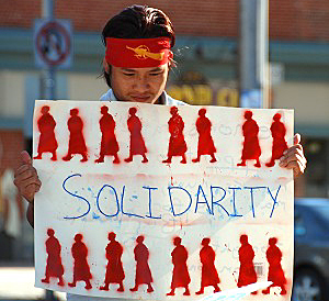 A CFOB member holds a sign expressing support of the monks marching in Burma. (Samira Bouaou/Epoch Times)